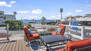 Une terrasse avec des sièges extérieurs donnant sur une plage.