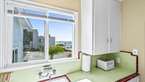 Une salle de bain avec une fenêtre, un lavabo, des toilettes et un miroir.
