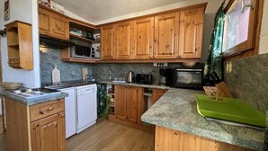 A compact kitchen with wooden cabinets, a microwave, a toaster, and a coffee maker. - 20m from ski slopes, 2nd floor, view ski slopes, balcony, 48m², La Plagne (La Plagne)