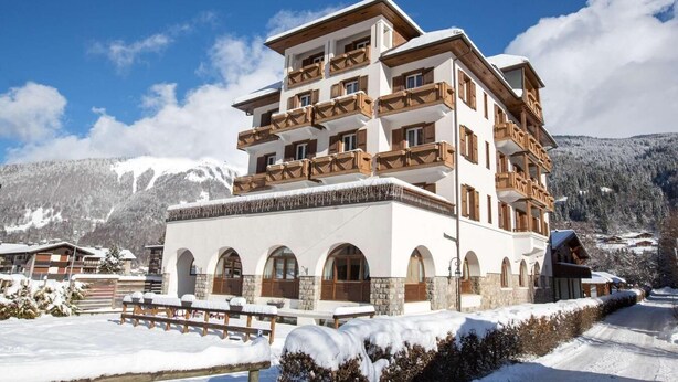 A multi-story hotel with balconies, arched windows, and a snowy mountain backdrop. - 2nd floor, balcony, parking, tv, ski locker, 45m², Morzine (Morzine)