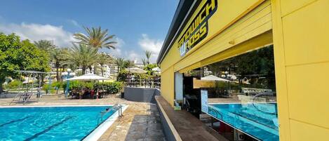 Uma área de piscina com um edifício amarelo identificado como