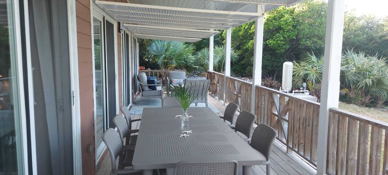 Huge outdoor covered wrap-around porch with dining for 8 and a sitting area