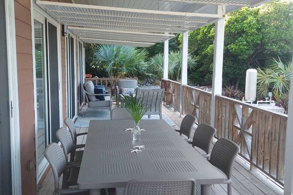 Huge outdoor covered wrap-around porch with dining for 8 and a sitting area