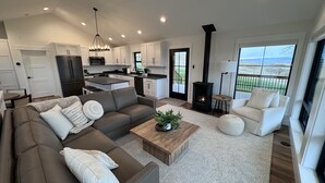 A modern living room with a sofa, coffee table, and a fireplace. - Modern Farmhouse with Breathtaking Views! (Bozeman)
