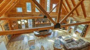 Un vaste espace de vie de style loft, doté de hauts plafonds, de poutres apparentes et de grandes fenêtres.