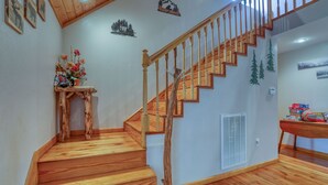 Eine Holztreppe mit einer Holzhandlauf und ein kleiner Tisch mit einem Blumenstrauß auf der Zwischenebene.