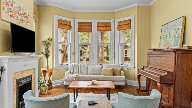 Una sala de estar acogedora con chimenea, un sofá, una mesa de centro y un piano.