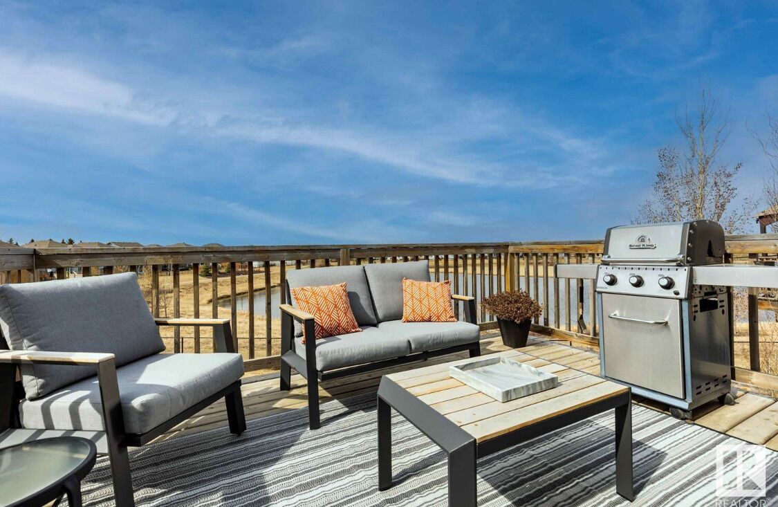 Una terraza con una parrilla, un sofá y una mesa.