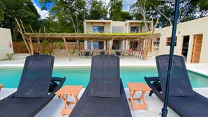 A poolside area with lounge chairs and a pergola. - Hotel y Eco-Cabañas Azul María Bacalar (Bacalar)