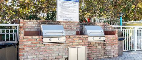 Ett område med grillplats, inklusive instruktioner för grillarna, en mur av tegelsten och en grind av metall.