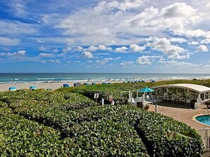 A resort with a pool, beach umbrellas, and a view of the ocean. - Berkshire on the Ocean (Delray Beach)