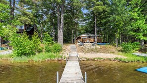 A wooden dock leading to a cabin surrounded by dense forest. - Lakefront Pine Retreat in Lewiston - 1 Mile from Garland Golf Resort (Lewiston)