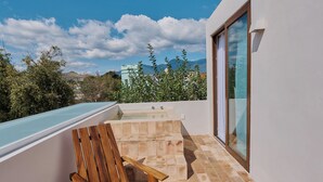 A modern outdoor area with a pool, a wooden chair, and a glass-enclosed space. - Casona Juárez - Porfirio / private plunge pool (Oaxaca de Juárez)