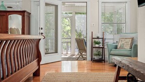 A spacious room with a wooden bench, a teal sofa, and a wooden table.