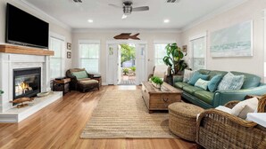 A living room with a fireplace, television, and green sofa.