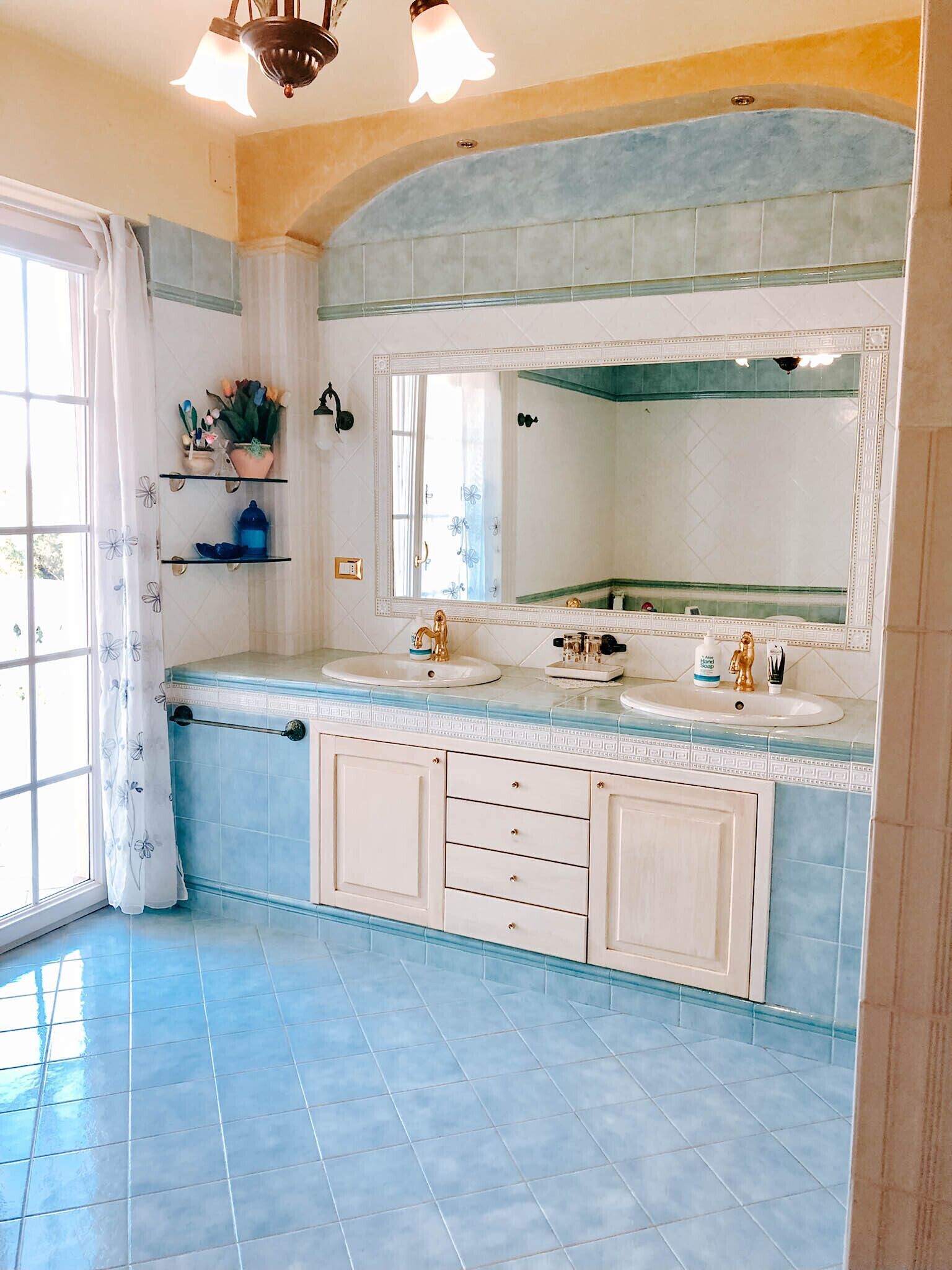 Un bagno con uno specchio grande, due lavandini e uno spazio doccia.