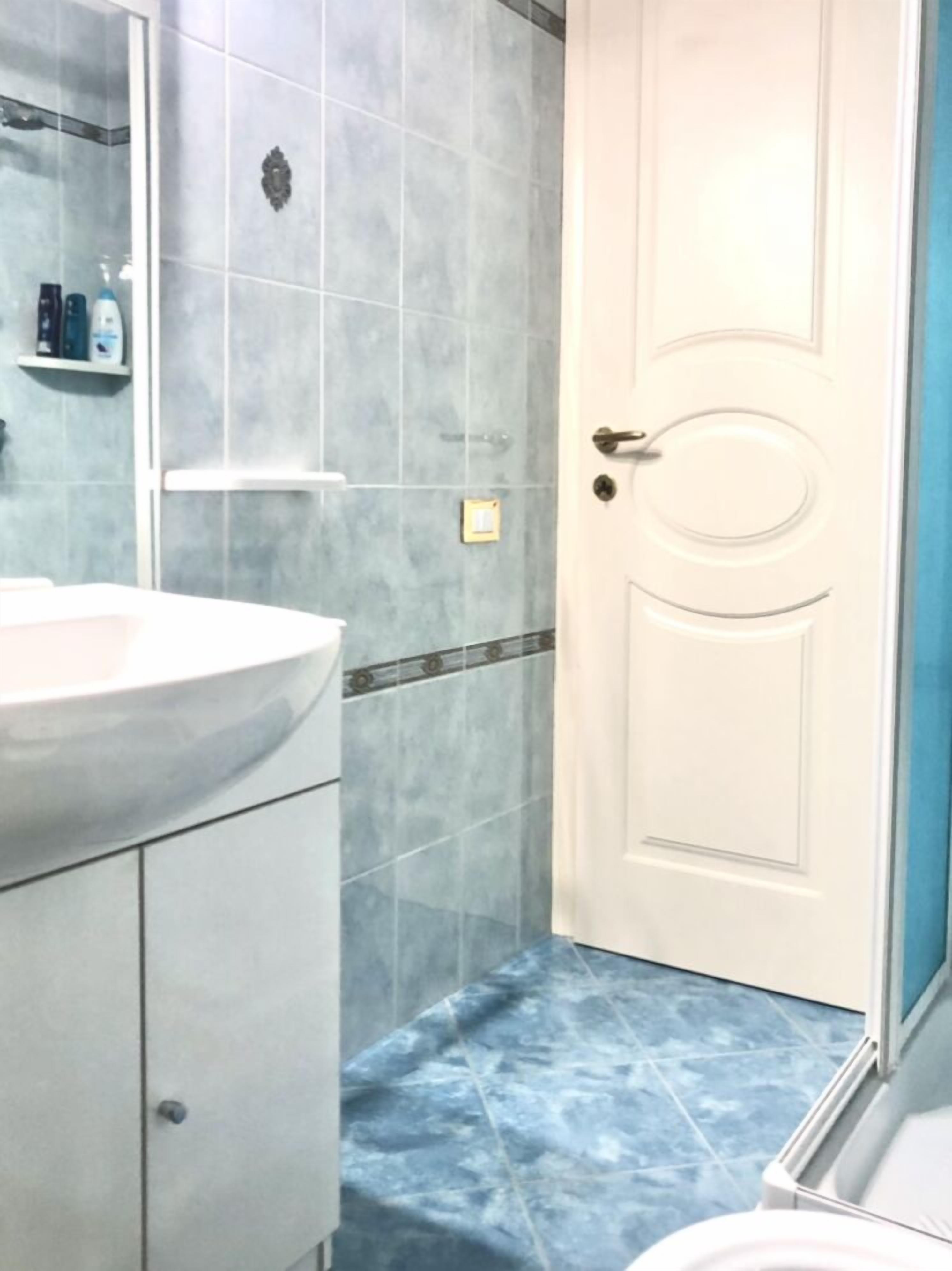 A bathroom with a white sink, a mirror, and a door.
