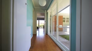 Un couloir doté d’un plancher en bois et de grandes fenêtres.