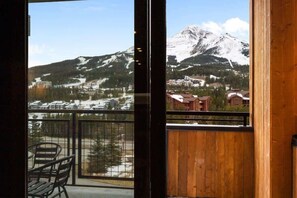 Ein Balkon mit Blick auf einen schneebedeckten Berg und eine darunterliegende Stadt.