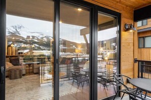 Ein modernes Interieur mit einer Glaswand, die einen Blick auf schneebedeckte Berge ermöglicht.