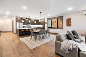 Eine moderne Küche mit dunklen Holzschränken, Edelstahlgeräten und Pendelleuchten.