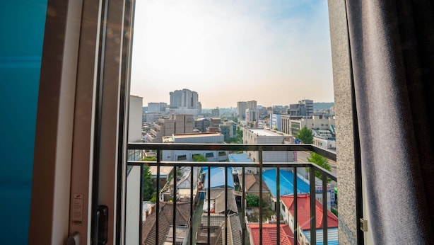 A cityscape through a window with a view of buildings and a clear sky.