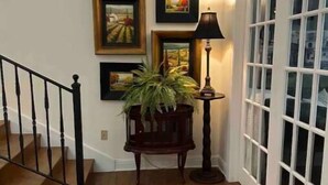 A wooden-floored hallway with a staircase on the left, a potted plant, and framed pictures on the wall. - Plenty of room near square (Oxford)