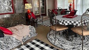 A dining area with a checkered tablecloth, black and white patterned rug, and a ceiling fan. - Plenty of room near square (Oxford)