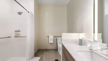A modern bathroom with a shower, toilet, and sink.