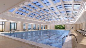 A large indoor swimming pool with a skylight ceiling, sun loungers, and a view of the city. - Crowne Plaza Chengdu Tianfu New Area by IHG (Chengdu)