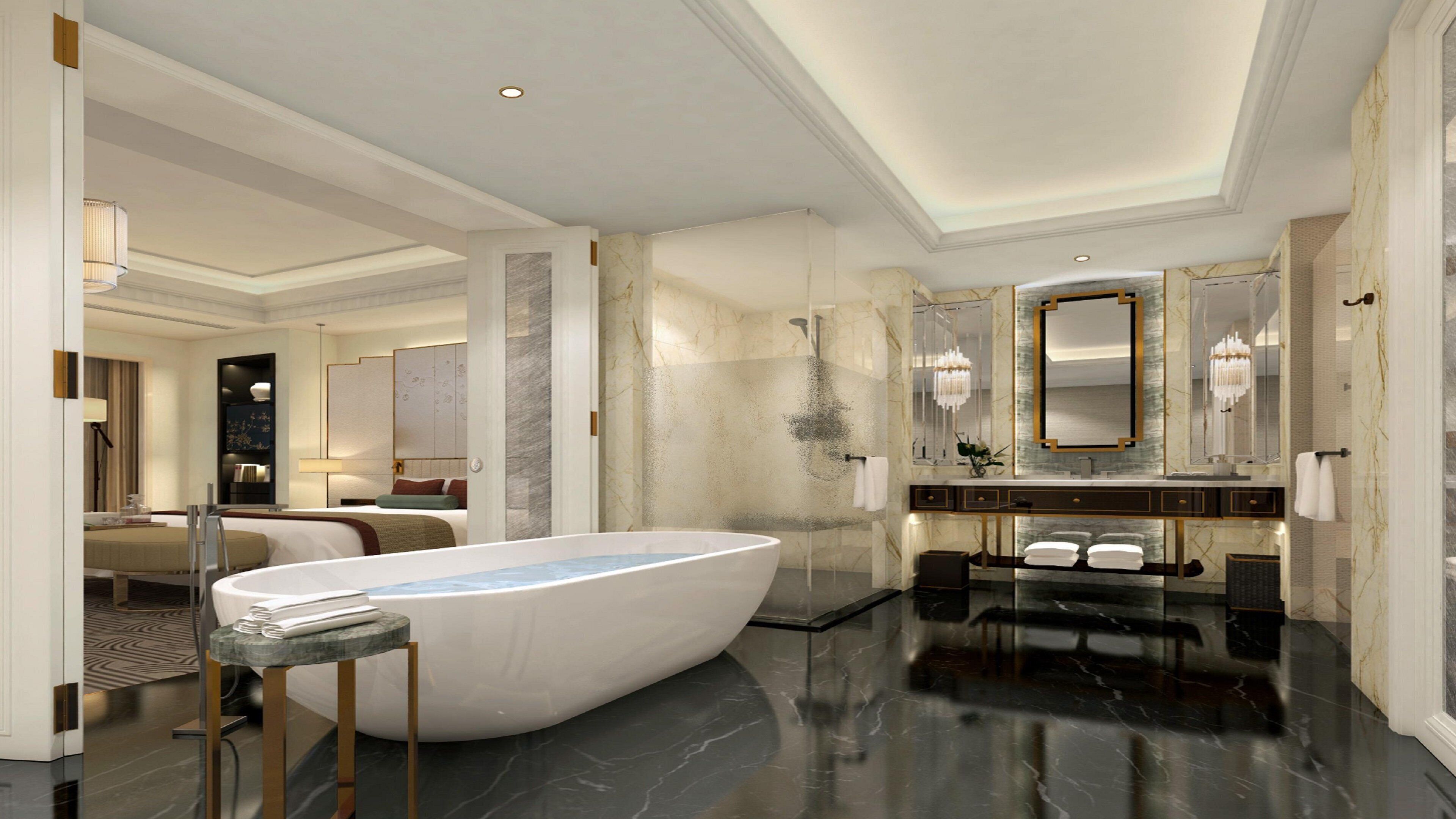 A luxurious bathroom with a large freestanding bathtub, marble walls, and a modern vanity with a large mirror.