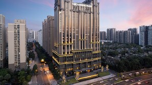 Korkea kerrostalo, jonka katolla on kyltti, jossa lukee ”CROWNE PLAZA”. Rakennuksessa on useita kerroksia, ja sen arkkitehtuuri on modernia.