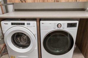 Zwei Frontlader-Waschmaschinen, Whirlpool und LG, unter einer Küchenarbeitsplatte eingebaut.