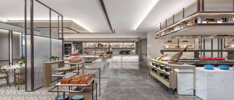 A modern kitchen with marble countertops, stainless steel appliances, and a variety of food items displayed on shelves and tables.