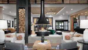 Eine moderne Lobby mit Kamin, Sitzgruppe und großem Fenster.