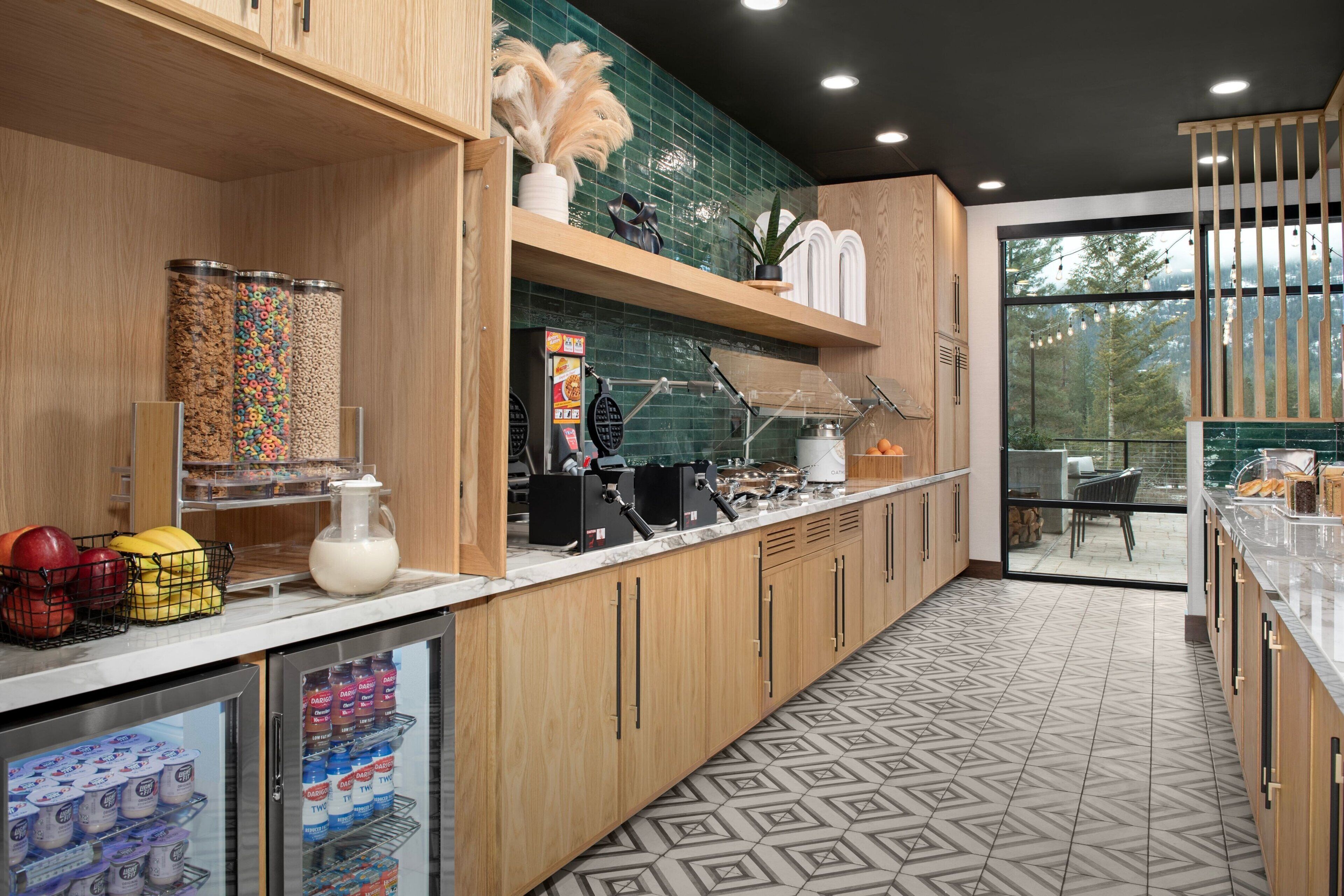 A modern kitchen with wooden cabinets, a marble countertop, and a patterned floor.
