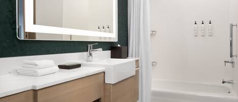 Un baño moderno con un espejo grande, dos lavamanos, una ducha y una bañera.