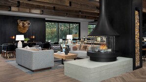 Ein modernes Wohnzimmer mit Kamin, Sofas und Essbereich.