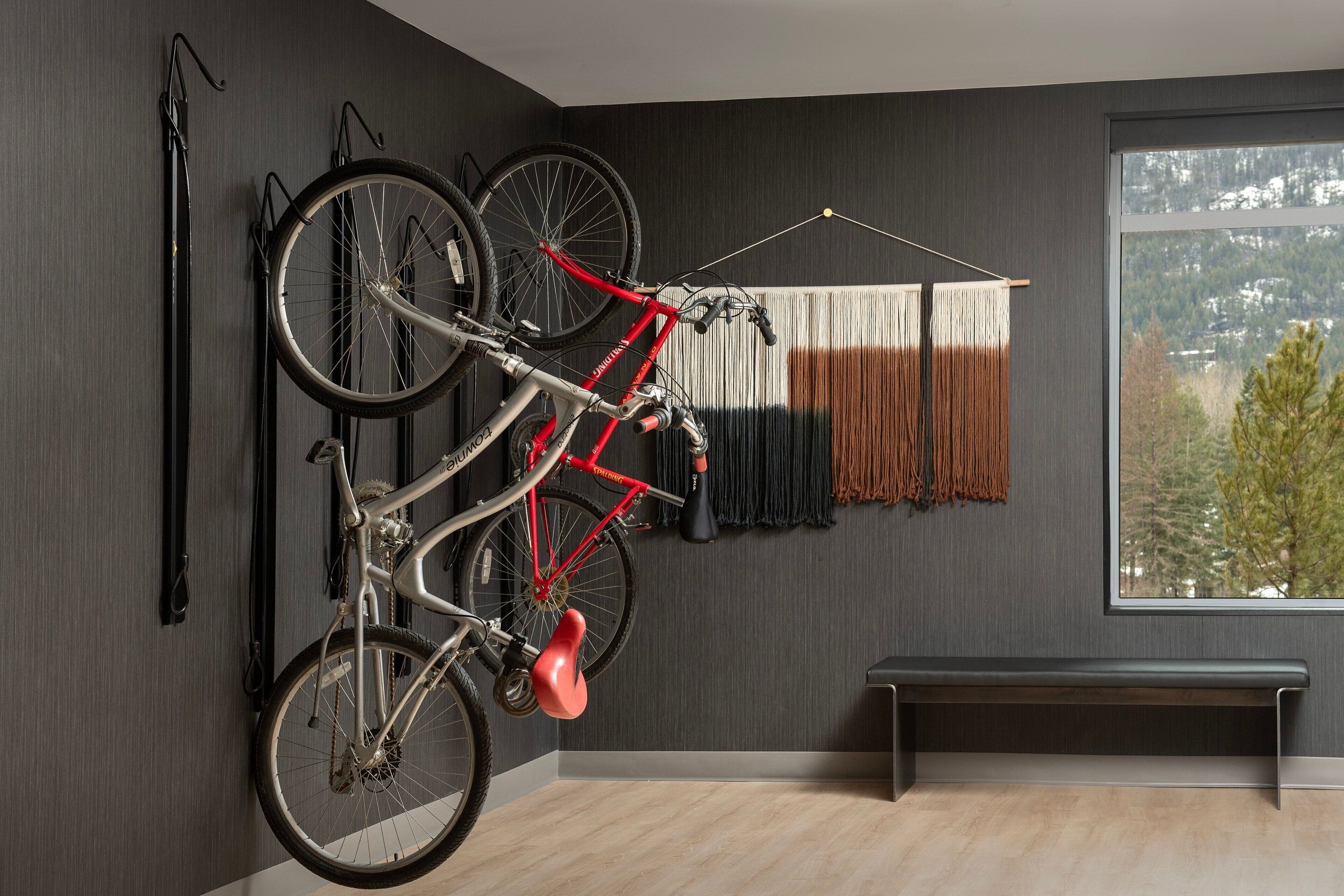 Een kamer met een fietsenrek, een bank en uitzicht op een bergachtig landschap.