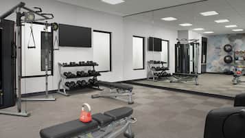 Ett gym med utrustning för styrketräning, hantlar och träningsmaskiner.