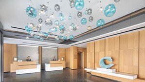 A modern reception area with two reception desks, a marble floor, and a ceiling with hanging spherical light fixtures. - Fairfield By Marriott Yangzhou Slender West Lake (Yangzhou)