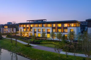 Un hotel moderno con techo plano, amplias ventanas y un césped bien cuidado.