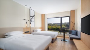 A hotel room with two beds, a sofa, a TV, and a large window offering a city view. - Fairfield By Marriott Yangzhou Slender West Lake (Yangzhou)