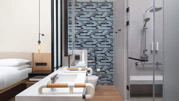 A modern bathroom with a shower, toilet, and a large mirror.
