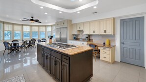A modern kitchen with a central island, built-in appliances, and ample natural light from large windows. - Fun-for-all! Pool! Private Pickleball Court! Game room! (Tucson)