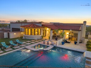 A swimming pool with lounge chairs, a covered seating area, and a patio with potted plants. - Fun-for-all! Pool! Private Pickleball Court! Game room! (Tucson)