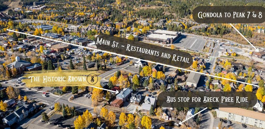 An aerial view of Main St. with restaurants and retail, a bus stop for Breck free ride, and a historic brown building.