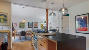 Una cocina moderna con armarios de madera, una isla central e iluminación colgante.