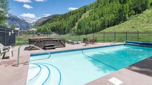 A swimming pool with a view of mountains and a forest.