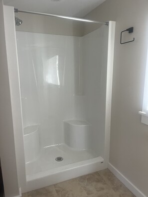 Een douche, handdoeken, zeep, toiletpapier